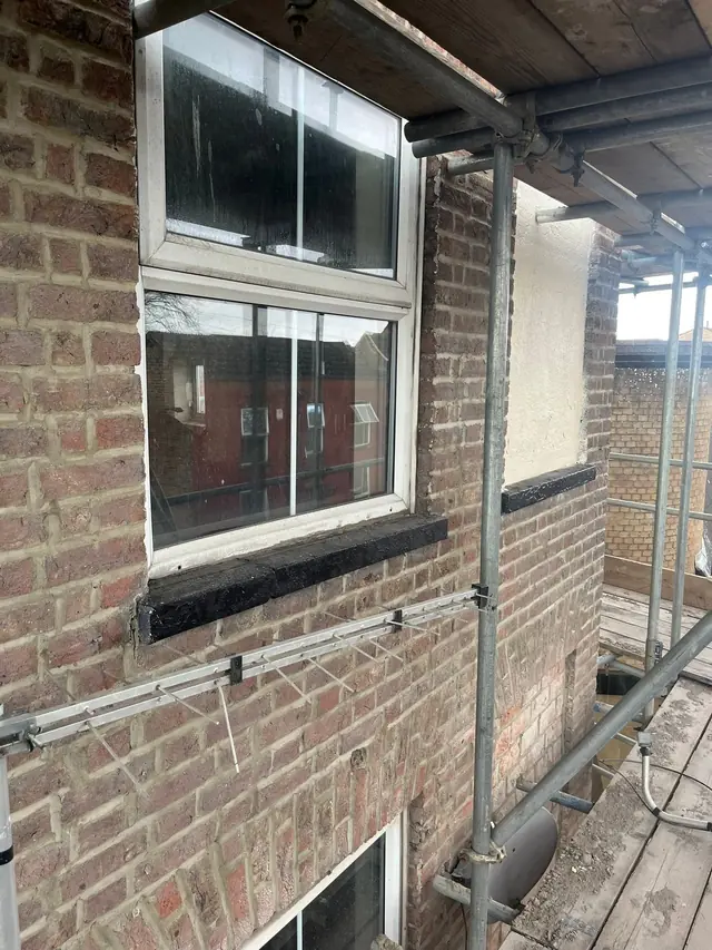 Brick elevation and window with scaffolding up for roofline work